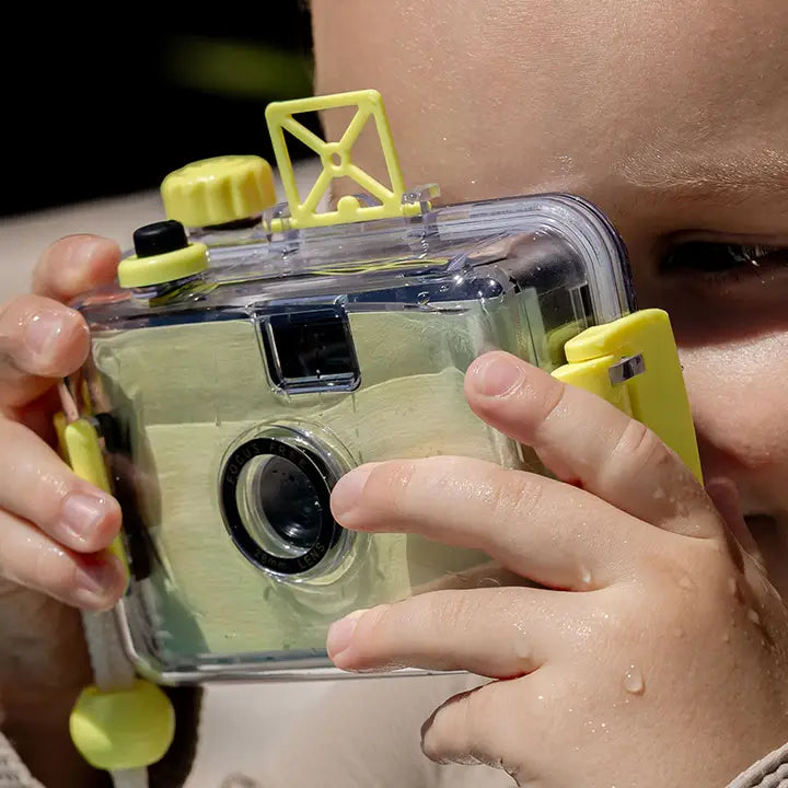 Person holding a yellow and clear underwater camera
